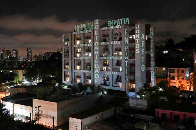 Слова «солидарность», «сопереживание», «привязанность» и фраза «спасибо, врачи, медсестры, сборщики мусора» на здании в Сан-Паулу, Бразилия.